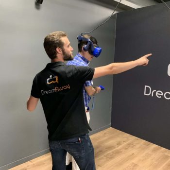 Un homme tend son bras pendant qu'un autre joue à un jeu de réalité virtuelle