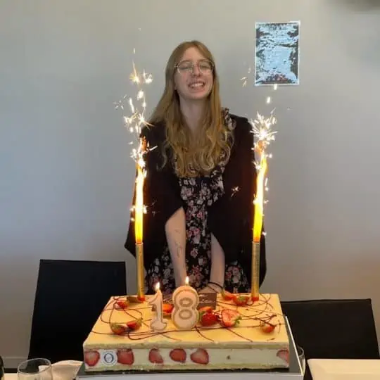 Une jeune femme devant un gâteau d'anniversaire pour ses 18 ans