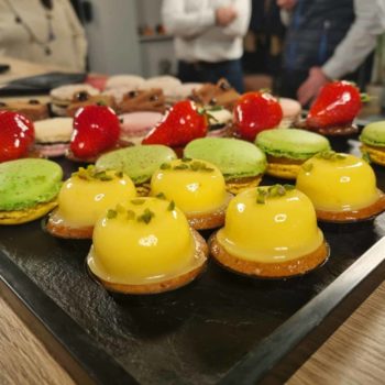 Des tartes au citron et des macarons sont posés sur une table