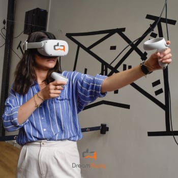 Une femme tends ses deux bras en avant et joue à un jeu de réalité virtuelle