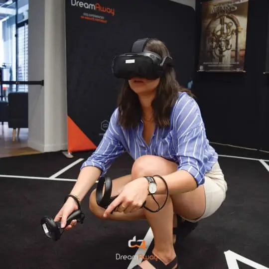 Une femme porte un casque de réalité virtuelle et est accroupie